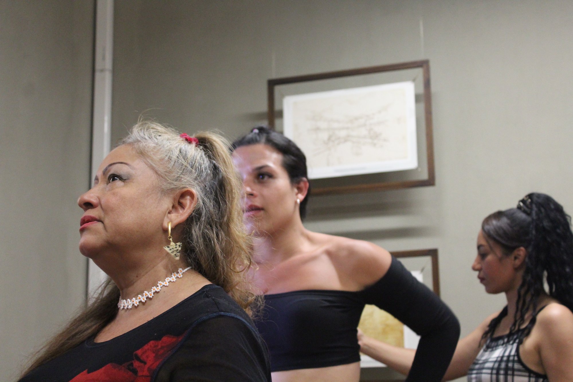 Tres mujeres adultas participan en una actividad dentro de una sala.