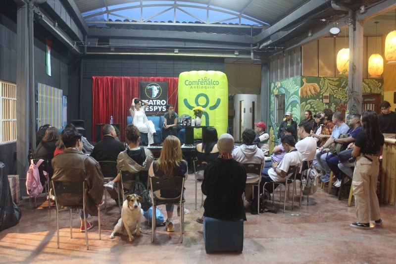 Personas adultas escuchan una conversación en una sala.
