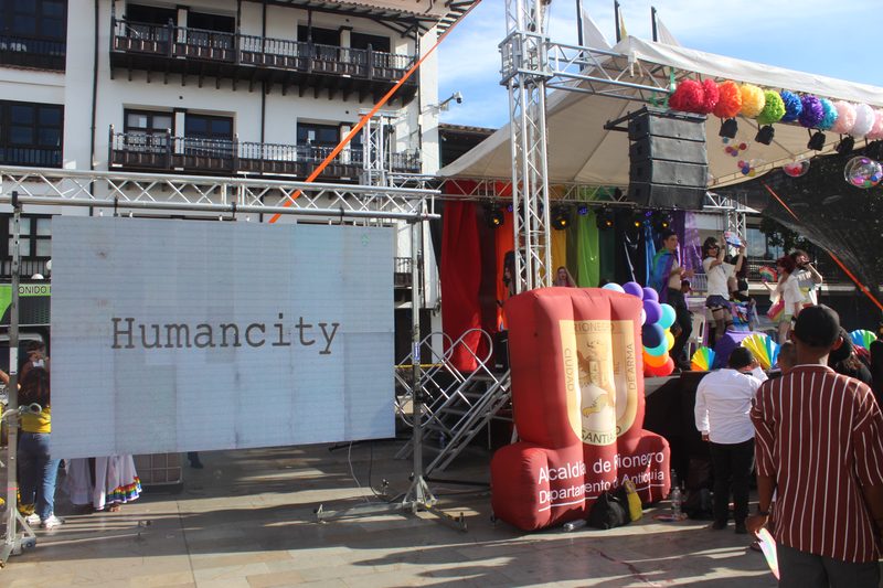 Una pantalla con la palabra Humancity aparece junto a una tarima al aire libre.